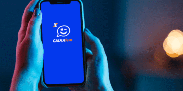 Pessoa segurando celular com aplicativo Caixa Tem aberto, relacionado aos novos pagamentos liberados.