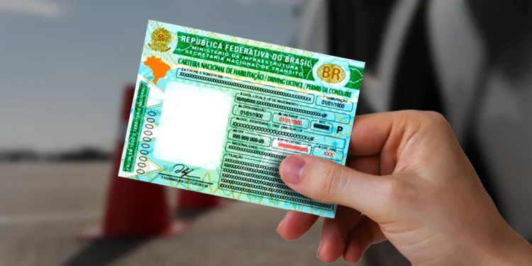 Foto de uma pessoa segurando a Carteira Nacional de Habilitação (CNH) com fundo desfocado
