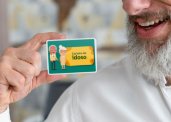 Homem sorridente segurando uma representação ilustrada da Carteira do Idoso nas mãos.