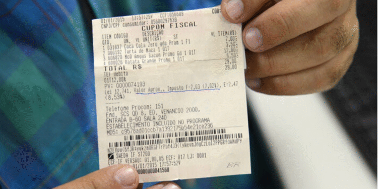 Pessoa segurando um cupom fiscal com CPF, ilustrando participação em sorteio de prêmios ao incluir CPF na nota.