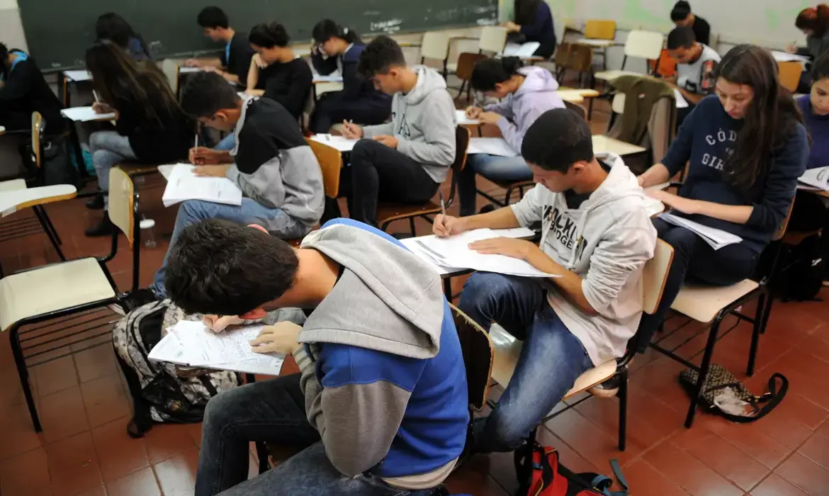 Alunos participando de uma avaliação escolar, demonstrando foco e dedicação.