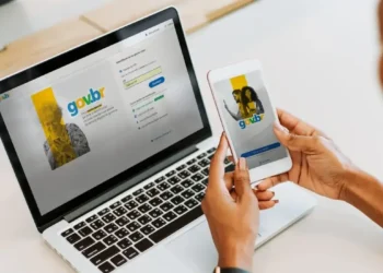 "Pessoa acessando o portal gov.br no celular e no computador, representando a atualização cadastral para acesso a benefícios."