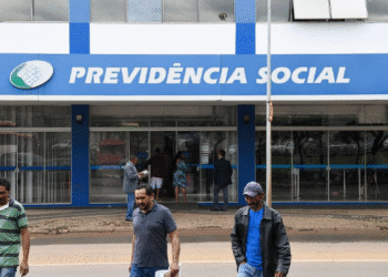 Imagem de uma agência da Previdência Social com pessoas entrando e saindo, ilustrando as ações do Governo para reduzir as filas do INSS.