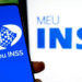 Logo do Meu INSS exibido em um celular, representando os serviços de consulta e agendamento de benefícios do INSS em 2025.