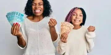 Mãe e filha comemorando com dinheiro em mãos, simbolizando o impacto positivo do auxílio de R$ 1.200 para mães solteiras.
