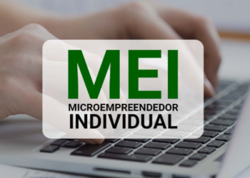 Mãos digitando em notebook com destaque para a sigla MEI - Microempreendedor Individual.