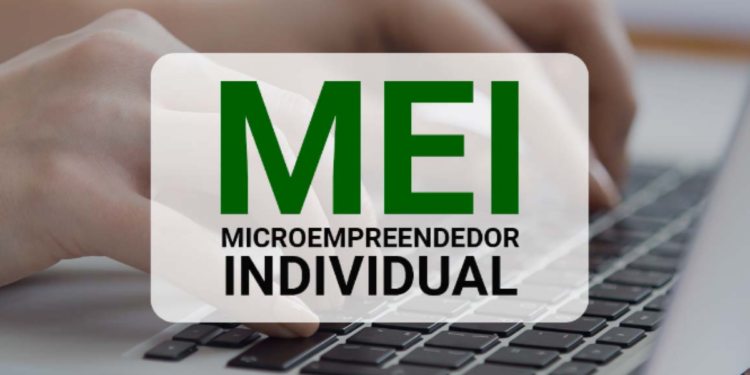 Mãos digitando em notebook com destaque para a sigla MEI - Microempreendedor Individual.