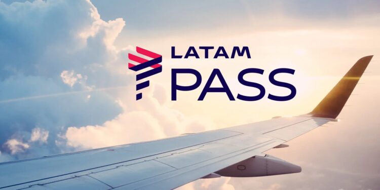 Logo do programa LATAM Pass com fundo de asa de avião em voo e céu ao entardecer