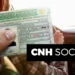 Pessoa segurando uma CNH dentro de um carro, simbolizando o acesso gratuito à habilitação pelo programa CNH Social.
