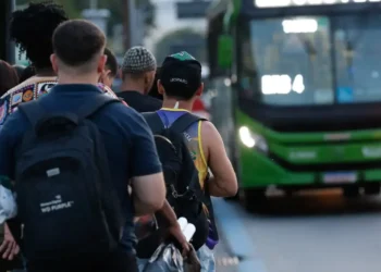 pessoas aguardam ônibus em fila no início do Dia do Trabalho