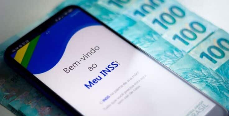Imagem do aplicativo Meu INSS exibido em um celular, com cédulas de 100 reais ao fundo, representando a facilidade de acesso aos serviços do INSS.