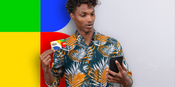 Homem segurando o cartão do Bolsa Família enquanto verifica seu celular.