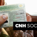 Carteira de Habilitação Social sendo exibida por um motorista, com o interior do carro ao fundo.