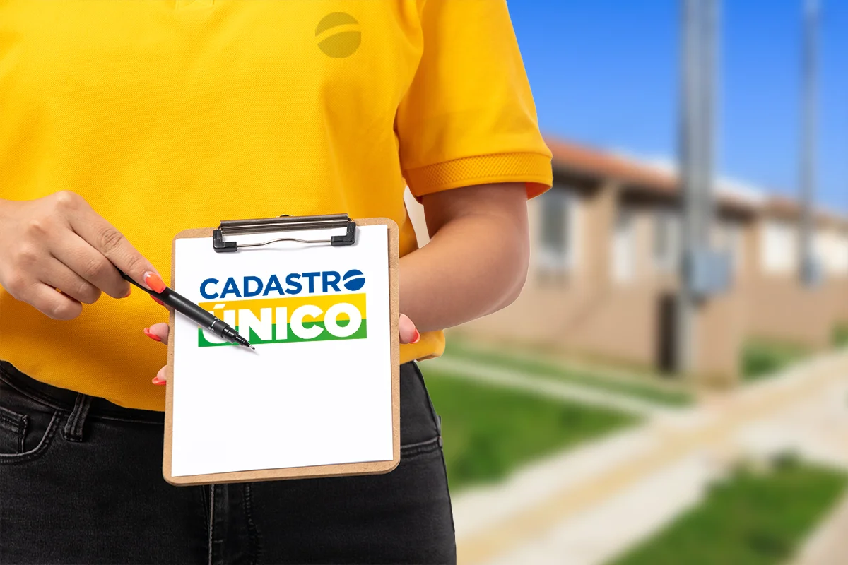 Imagem mostrando um membro da equipe com camisa amarela segurando uma prancheta com o logo do CadÚnico, representando o cruzamento de dados no Cadastro Único.