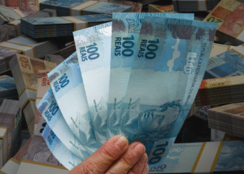 Montagem de notas de 100 reais e diversos maços de dinheiro, ilustrando valores financeiros.