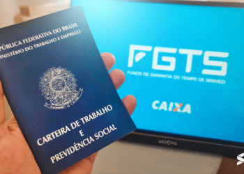 Carteira de Trabalho e tela do FGTS da Caixa Econômica Federal exibida no computador.