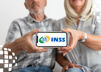 Casal de idosos segurando celular com logo do INSS na tela, simbolizando a facilidade de acesso aos serviços do INSS.