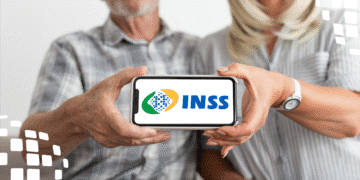 Casal de idosos segurando celular com logo do INSS na tela, simbolizando a facilidade de acesso aos serviços do INSS.