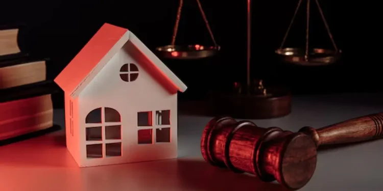 Martelo de juiz ao lado de uma casa em miniatura, simbolizando leilão de imóveis com oportunidades de desconto.