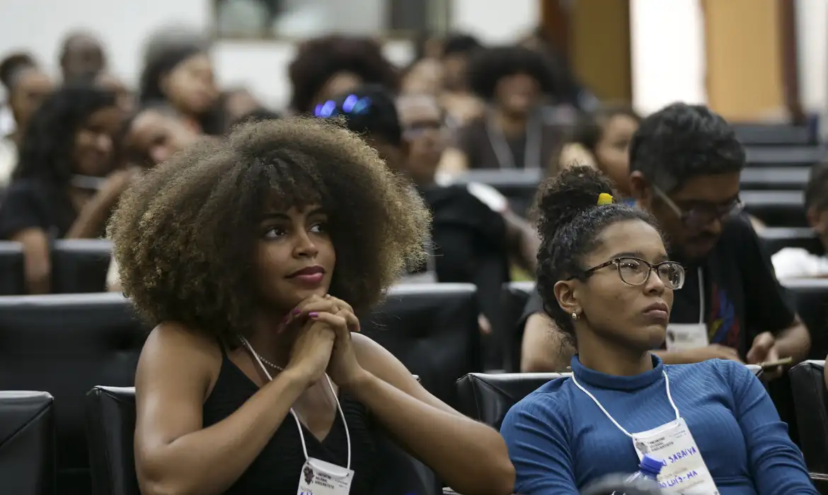 Alunos atentos durante aula presencial em ambiente educacional.