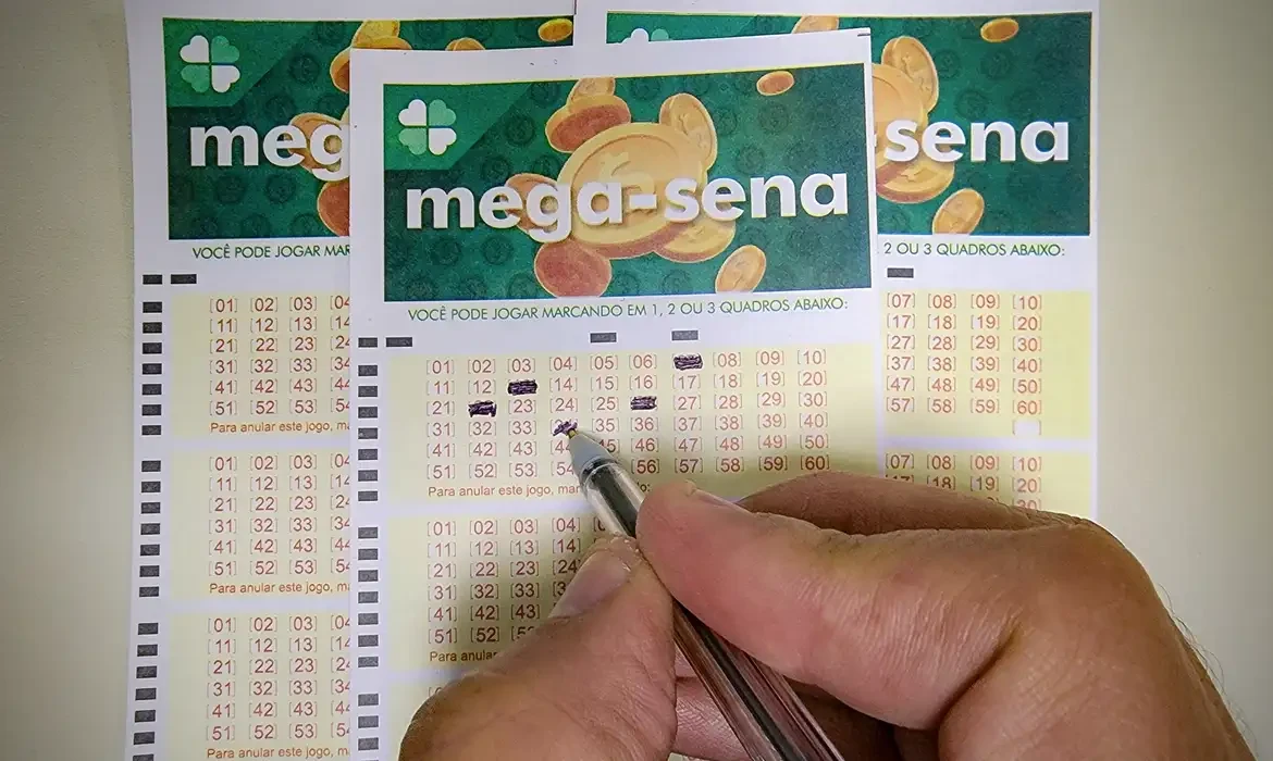 Pessoa marcando números em um bilhete da loteria Mega-Sena com uma caneta.