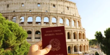Passaporte italiano segurado em frente ao Coliseu, em Roma.