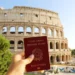 Passaporte italiano segurado em frente ao Coliseu, em Roma.