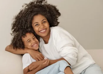 Mãe e filho felizes abraçados, representando mães beneficiadas pelo pagamento em Pernambuco.