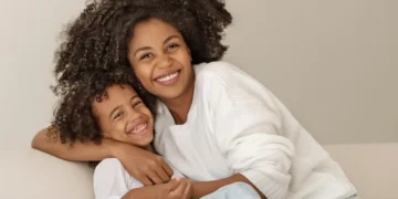 Mãe e filho felizes abraçados, representando mães beneficiadas pelo pagamento em Pernambuco.