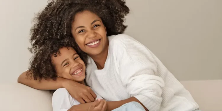Mãe e filho felizes abraçados, representando mães beneficiadas pelo pagamento em Pernambuco.