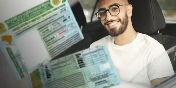 "Pessoa sorrindo enquanto segura a CNH, representando o processo de habilitação realizado pelo Detran."