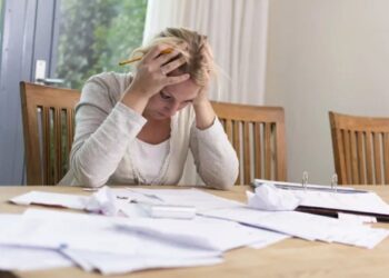 Pessoa calculando despesas e organizando contas para sair das dívidas