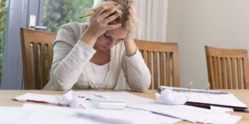 Pessoa calculando despesas e organizando contas para sair das dívidas