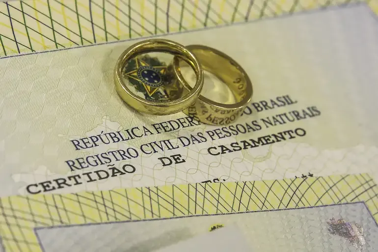  Duas alianças sobre uma certidão de casamento.