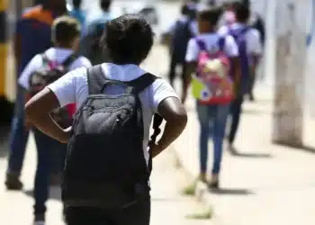 Estudantes a caminho da escola em período de comprovação de matrícula para o salário-família.