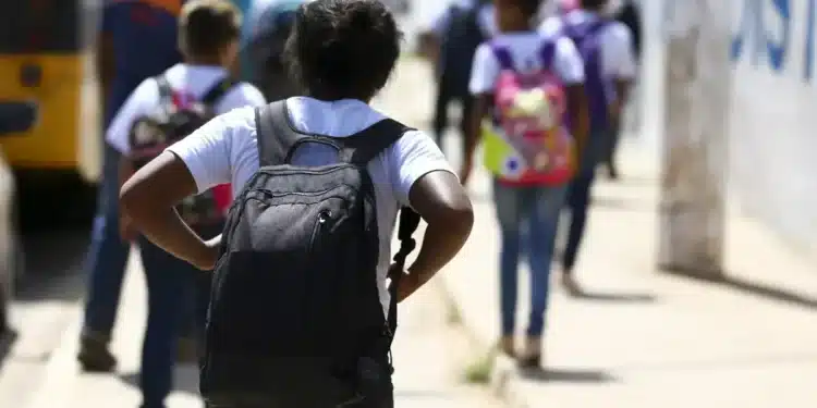 Estudantes a caminho da escola em período de comprovação de matrícula para o salário-família.