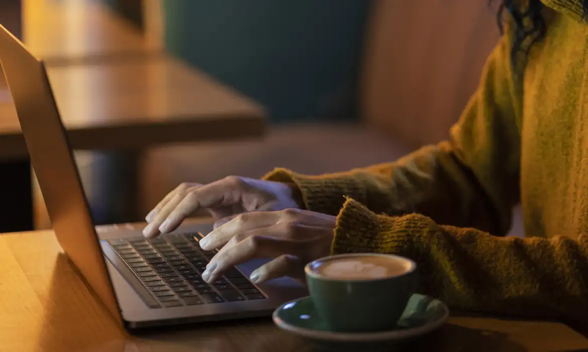  "Pessoa usando um laptop para acessar informações, ilustrando o processo de acessar o site do Detran do Rio de Janeiro."