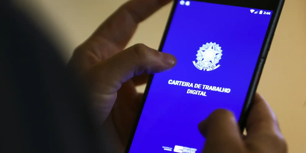 Pessoa acessando a Carteira de Trabalho Digital no celular para verificar o status do pagamento do Abono Salarial Pasep 2025.