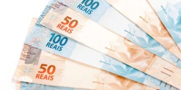 Notas de cinquenta e cem reais, representando o benefício financeiro do programa Devolve ICMS.