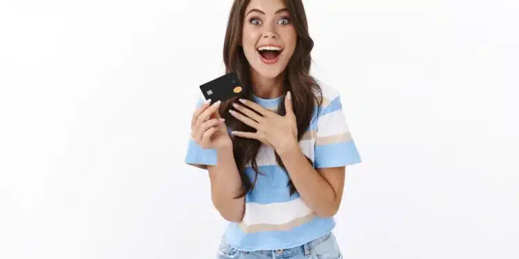 Jovem feliz segurando um cartão de crédito preto, simbolizando economia com cashback em 2025.