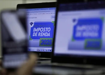 Tela de computador e celular mostrando informações sobre a declaração do Imposto de Renda 2025.