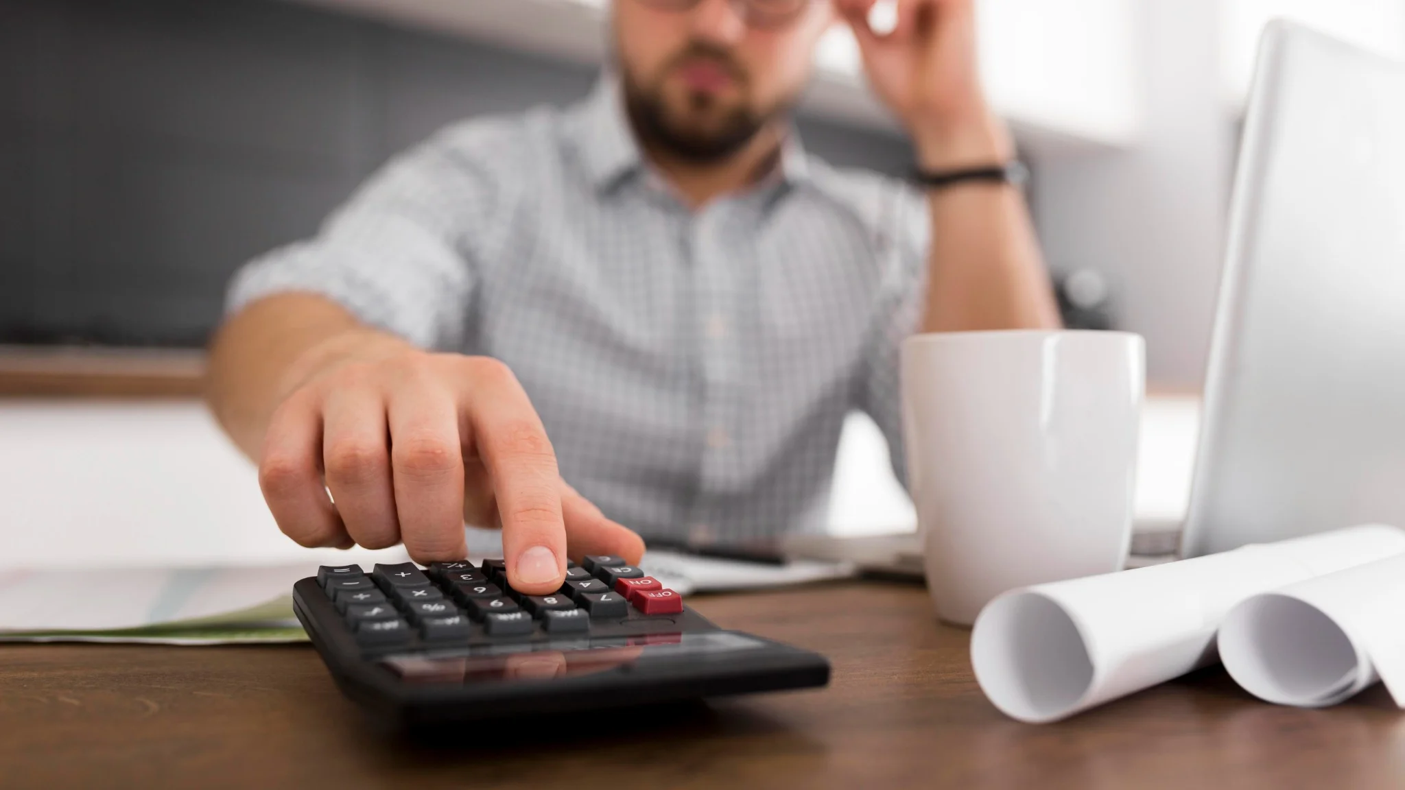 Homem calculando e analisando finanças enquanto negocia dívidas em casa.