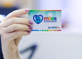 Cartão Mães de Pernambuco sendo segurado por uma mão, representando o benefício do programa estadual.