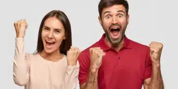 Casal comemorando vitória com expressões de felicidade e braços erguidos.
