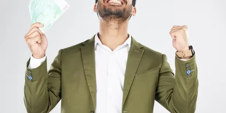 Homem feliz segurando dinheiro em notas verdes, comemorando vitória.