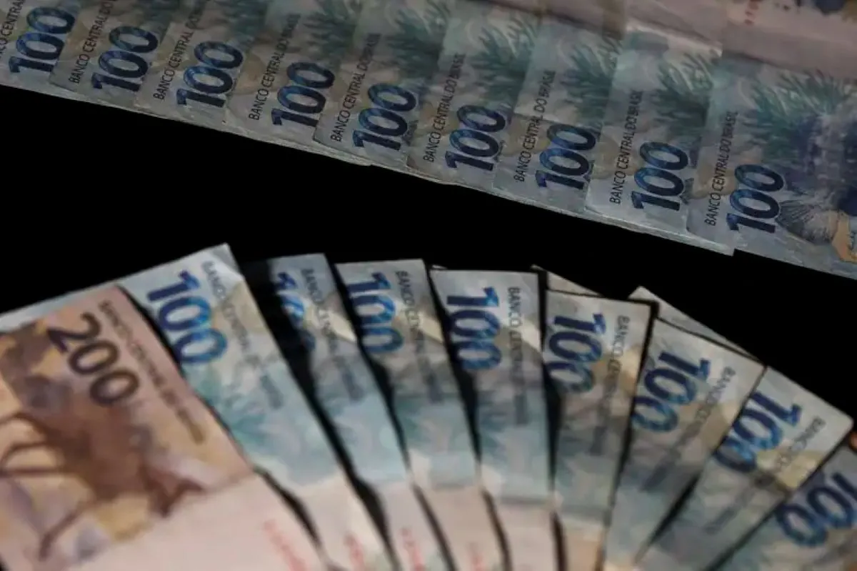  Notas de 100 e 200 reais organizadas em leque, representando planejamento financeiro.