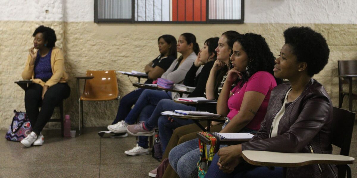 Estudantes em aula de cursinho popular atentos a uma explicação