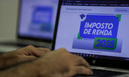 Pessoa preenchendo a declaração do Imposto de Renda 2025 no computador, com o logo da Receita Federal na tela.