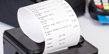Impressora térmica emitindo cupom fiscal com itens e valores detalhados.