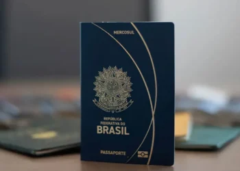 Passaporte brasileiro azul com brasão da República Federativa do Brasil em destaque.